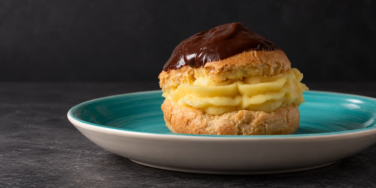 A cream-filled choux pastry with a chocolate topping