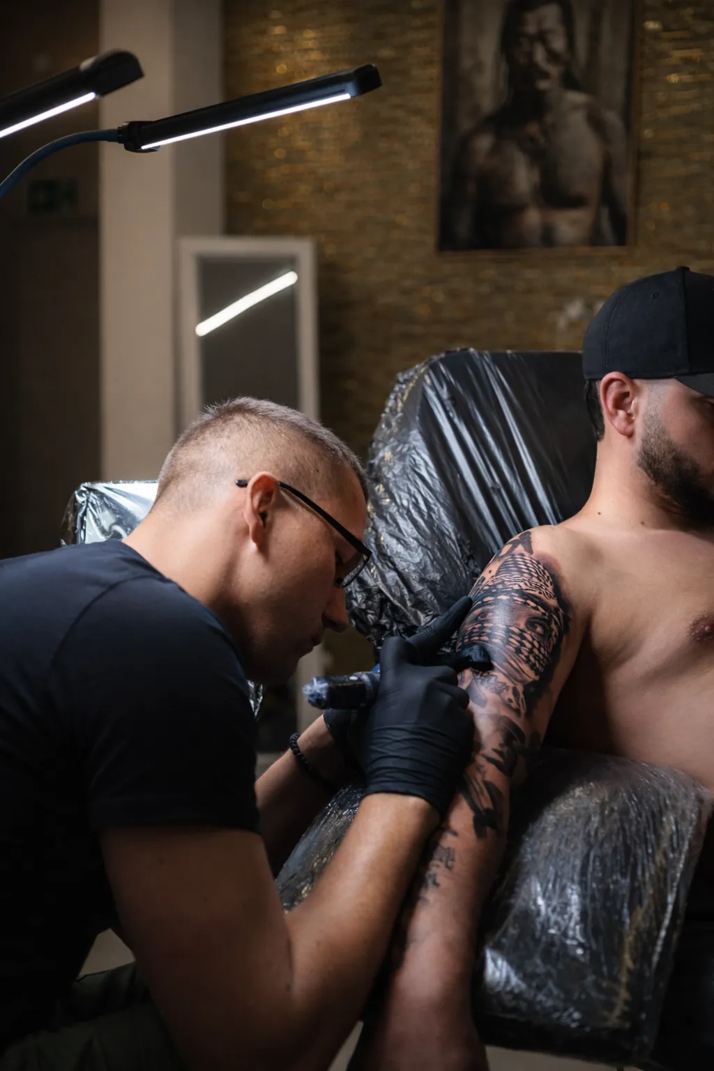 Tätowierer arbeitet konzentriert an Sleeve-Tattoo im INK SOCIETY Studio Kiel