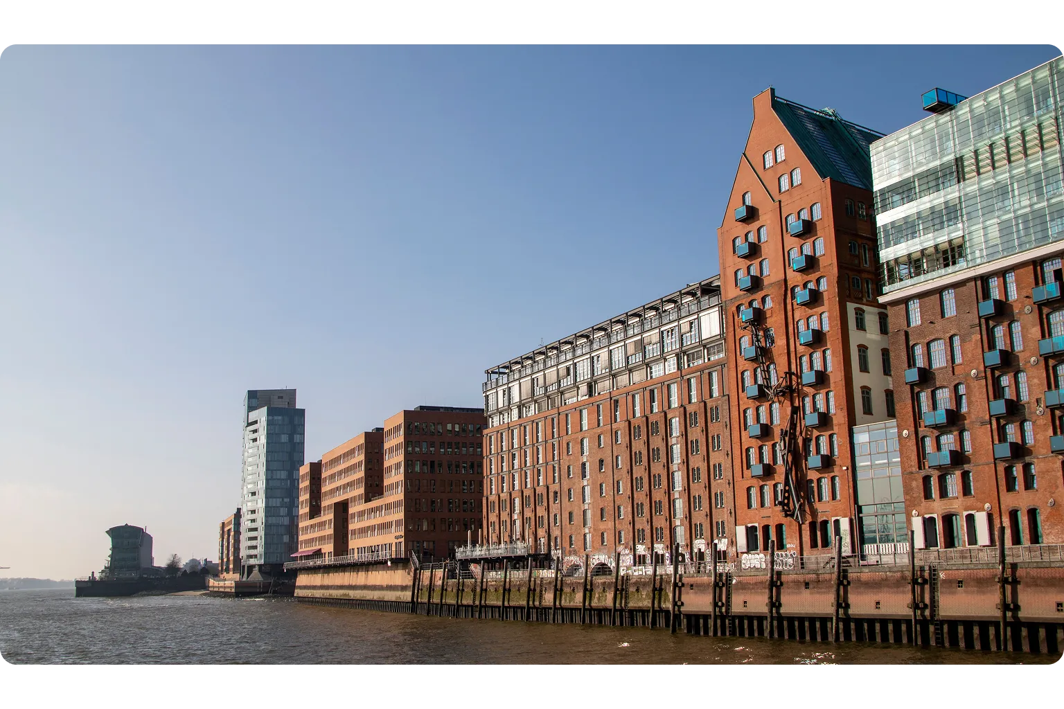 Blick auf den Hamburger Hafen mit historischen Backsteingebäuden an der Elbe – externer Datenschutzbeauftragter für Unternehmen in Hamburg