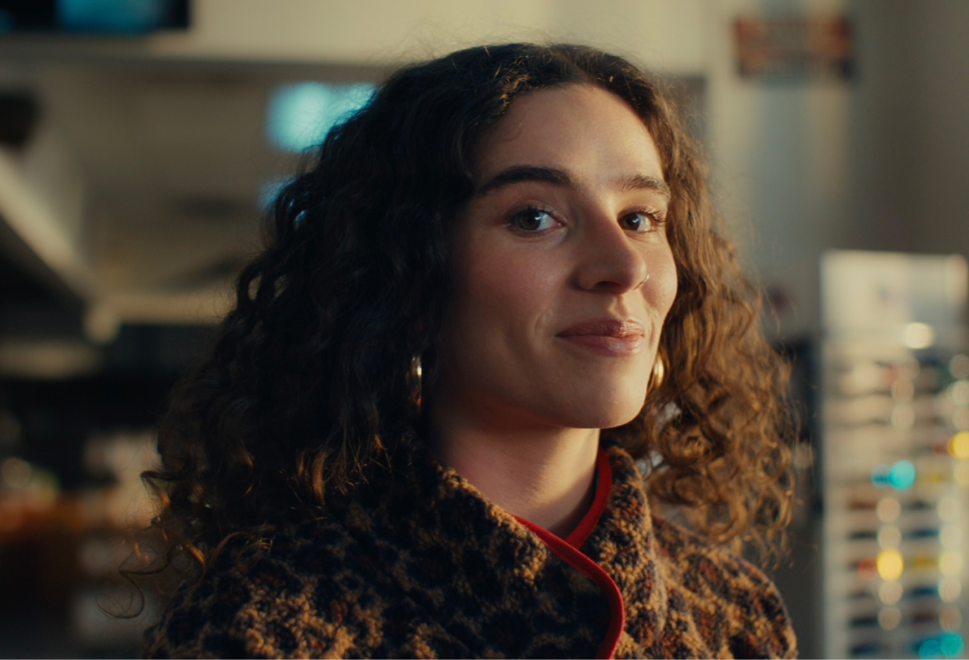 A woman with curly hair looking at the camera.