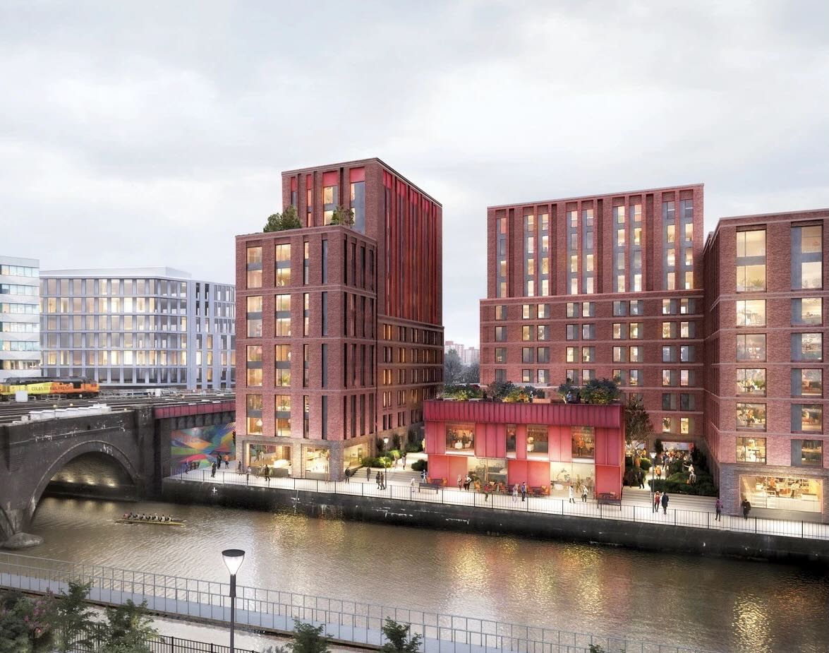 Modern brick buildings with lit windows by a river, a bridge on the left, and a rowing team on the water.