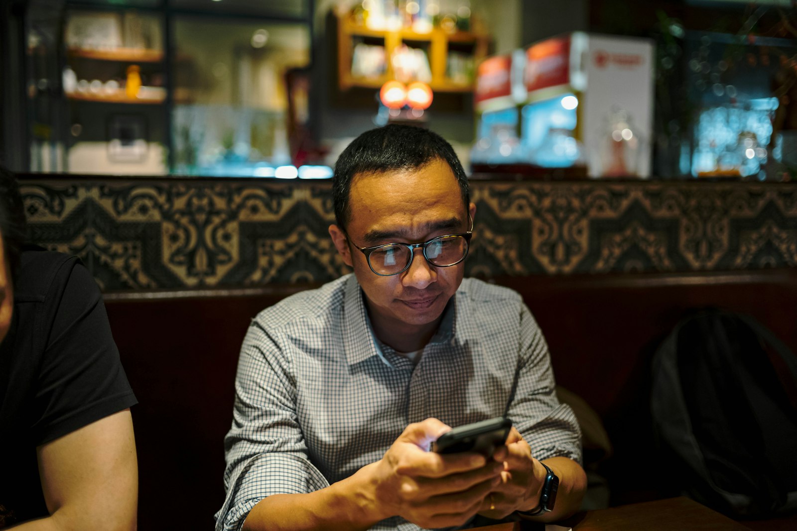 Person looking at their smartphone at a restaurant table