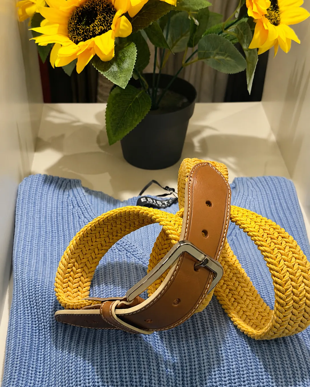 Ceinture tressée jaune sur pull bleu ciel