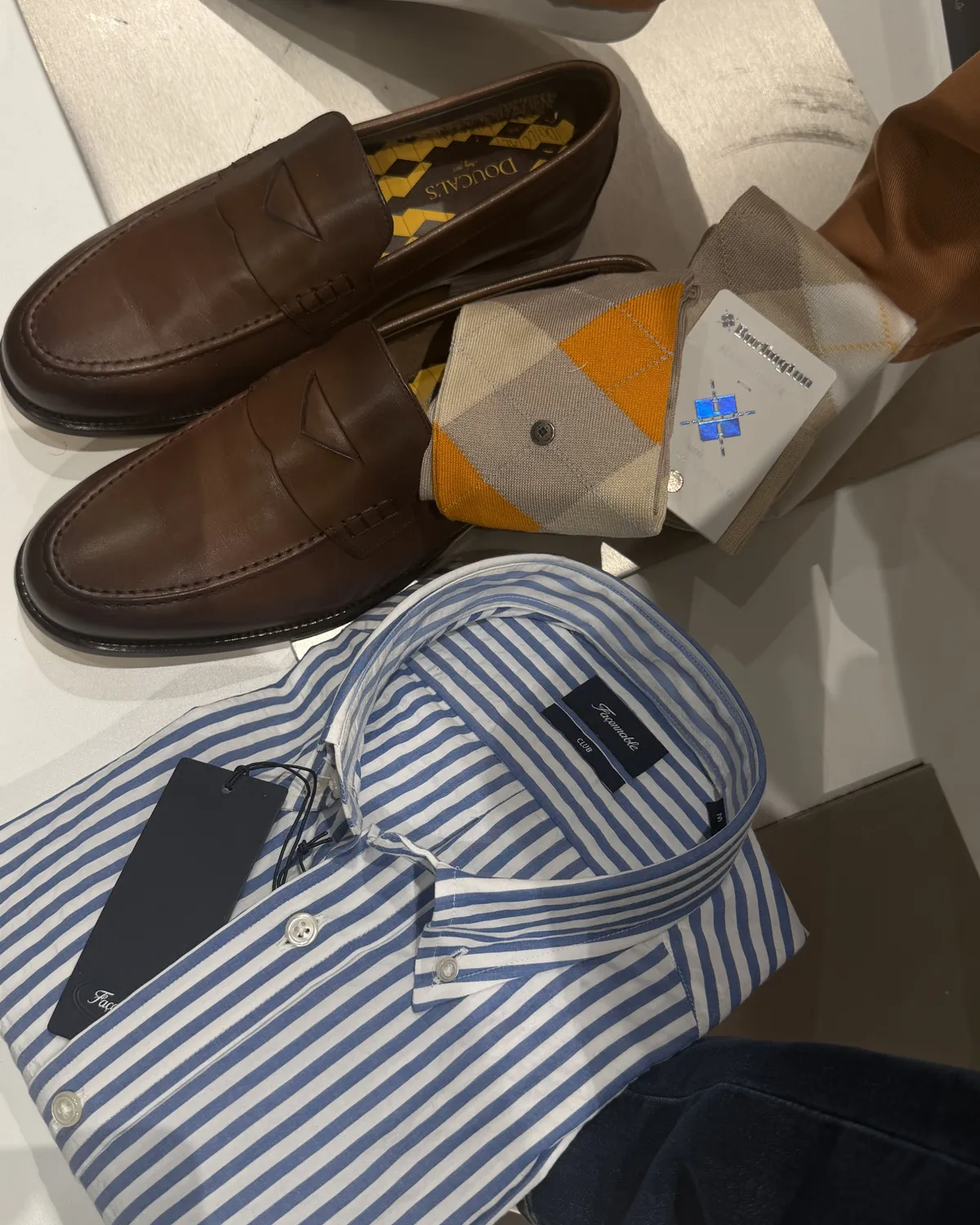 Mocassins en cuir, chaussettes à losanges et chemise rayée chez Roussel Hommes
