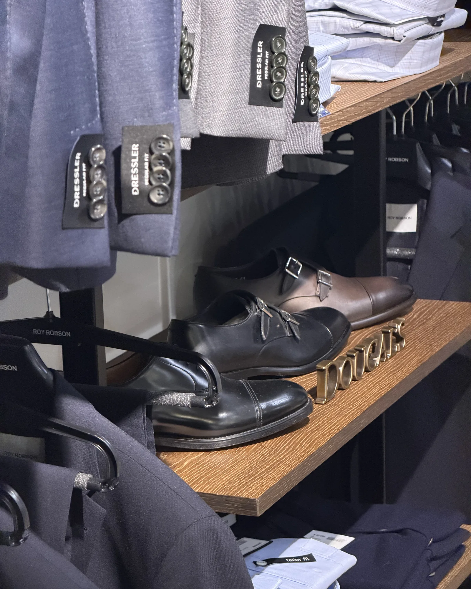 Étagère en chêne : chaussures Doucal's et pantalons chez Roussel Hommes