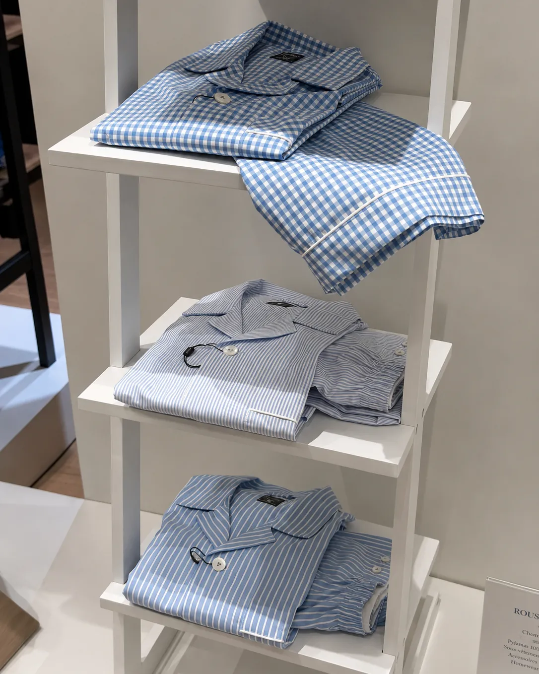 Pyjamas vichy et rayés pliés sur étagère blanche
