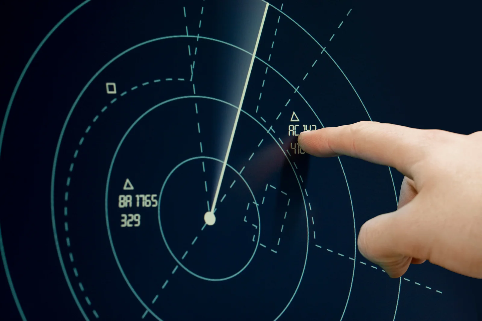Air traffic radar scope with a controller pointing at a transponder target
