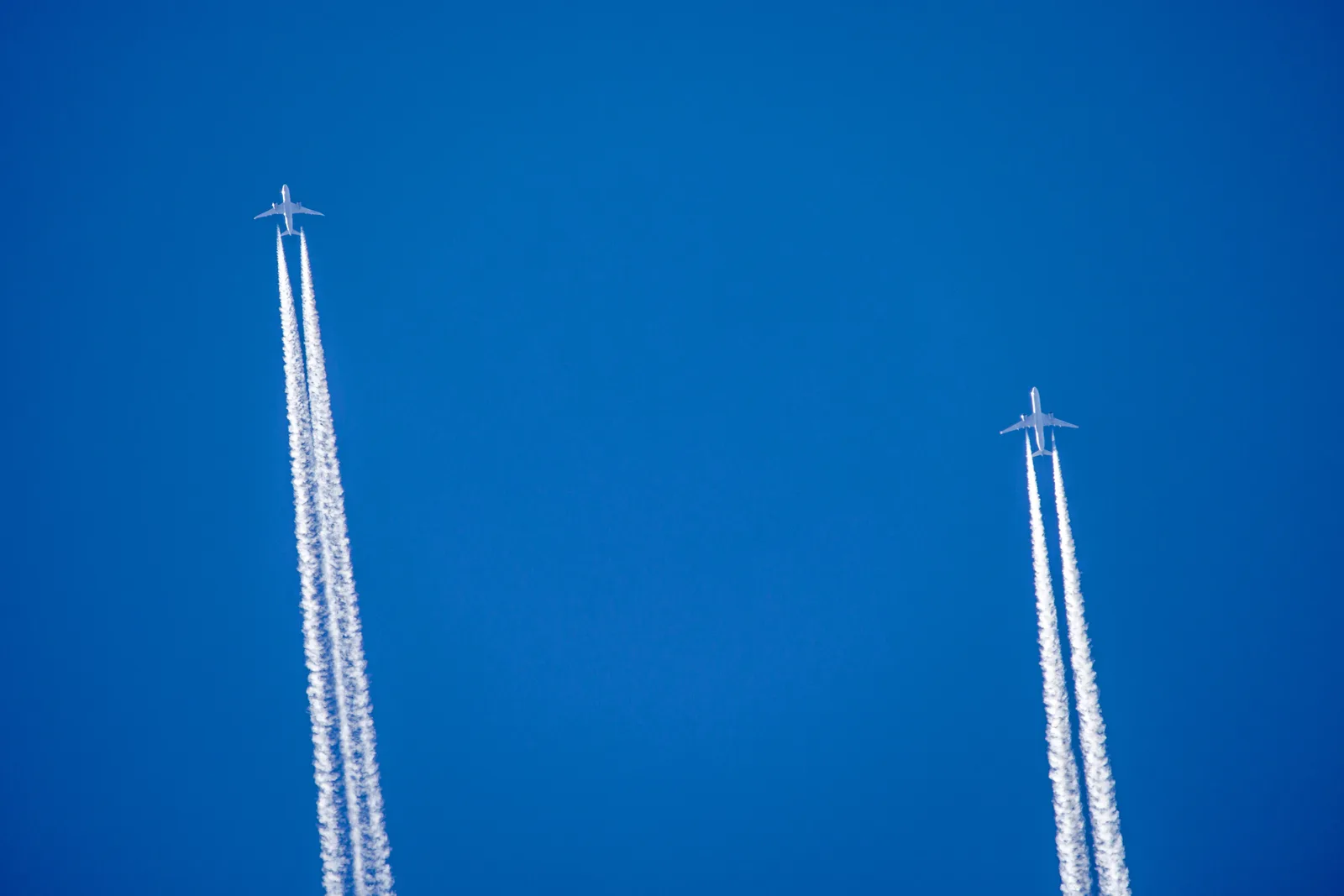 Two parallel jet contrails against a blue sky illustrating strategic lateral offset spacing