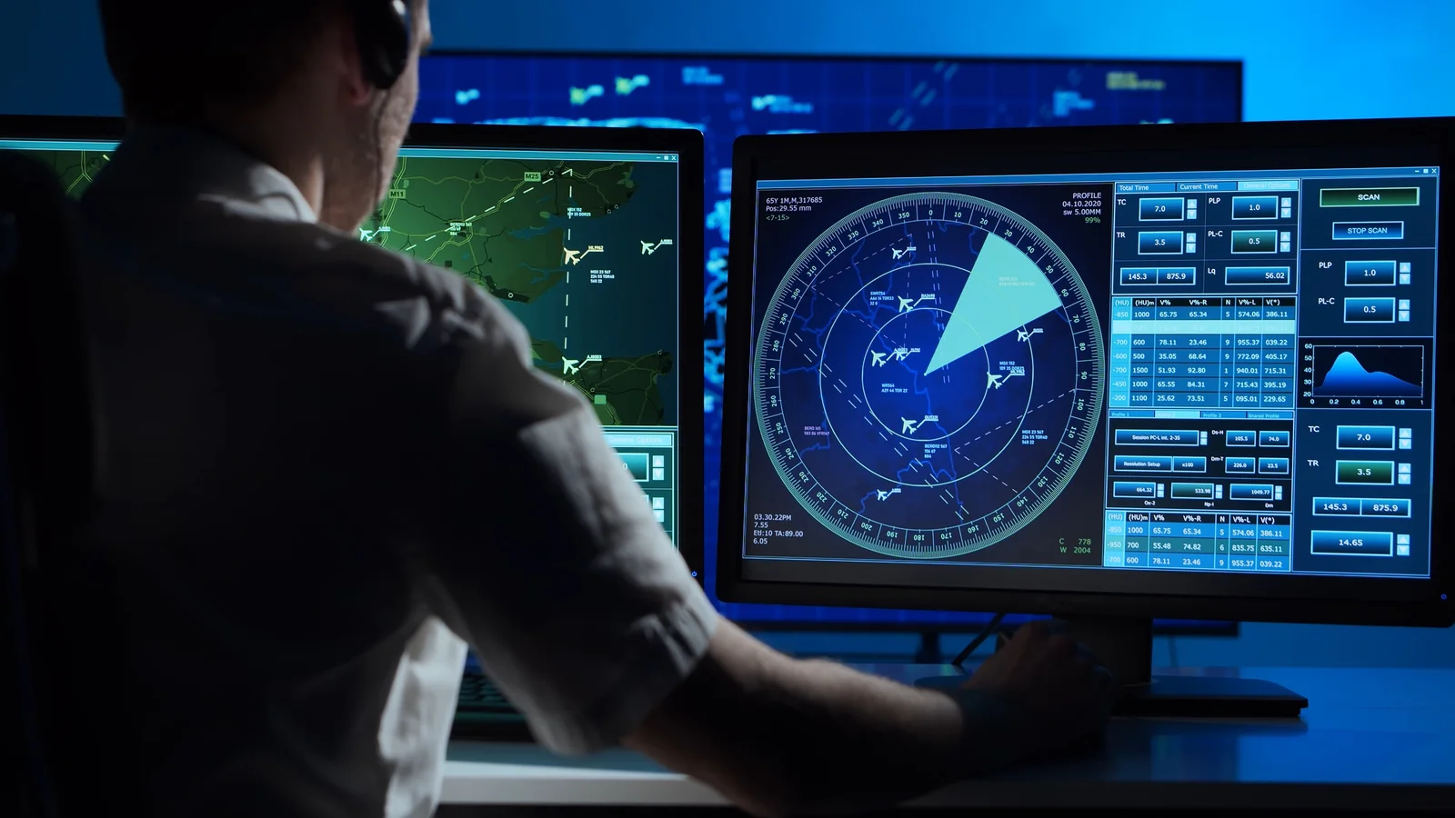 An air traffic controller monitoring a surveillance workstation