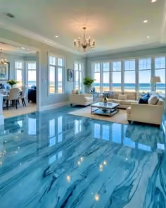 Bright living room with large windows, beige sofas, chandelier, and shiny blue marble floor.