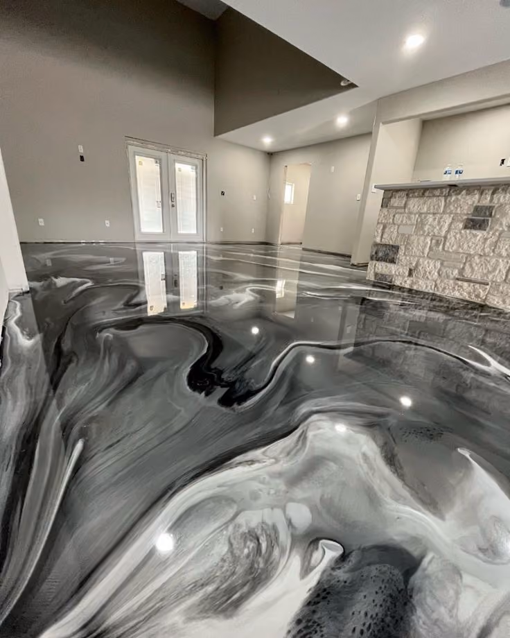 Room with high ceiling and polished black, white, and gray swirling epoxy floor.