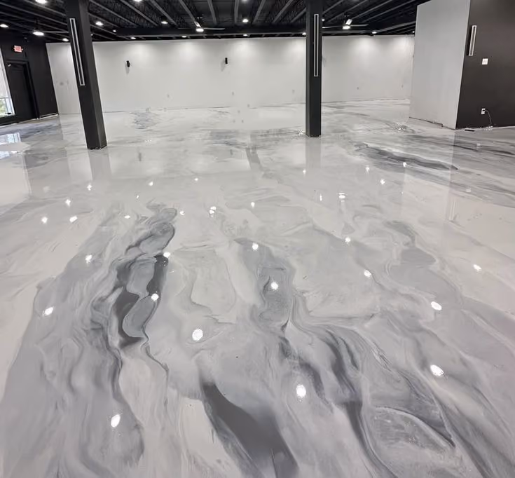 Empty room with polished gray and white marbled epoxy floor and black ceiling beams.