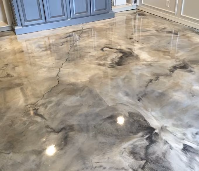 Glossy epoxy flooring with a marbled gray and white pattern in a room with blue cabinetry.