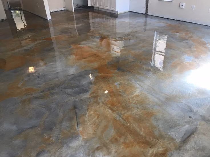 Glossy metallic epoxy floor with gray and copper-toned swirls in an empty room under renovation.