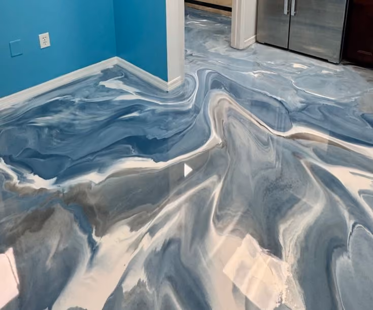 Blue, white, and gray epoxy resin floor with a swirling, marble-like effect in a kitchen area.