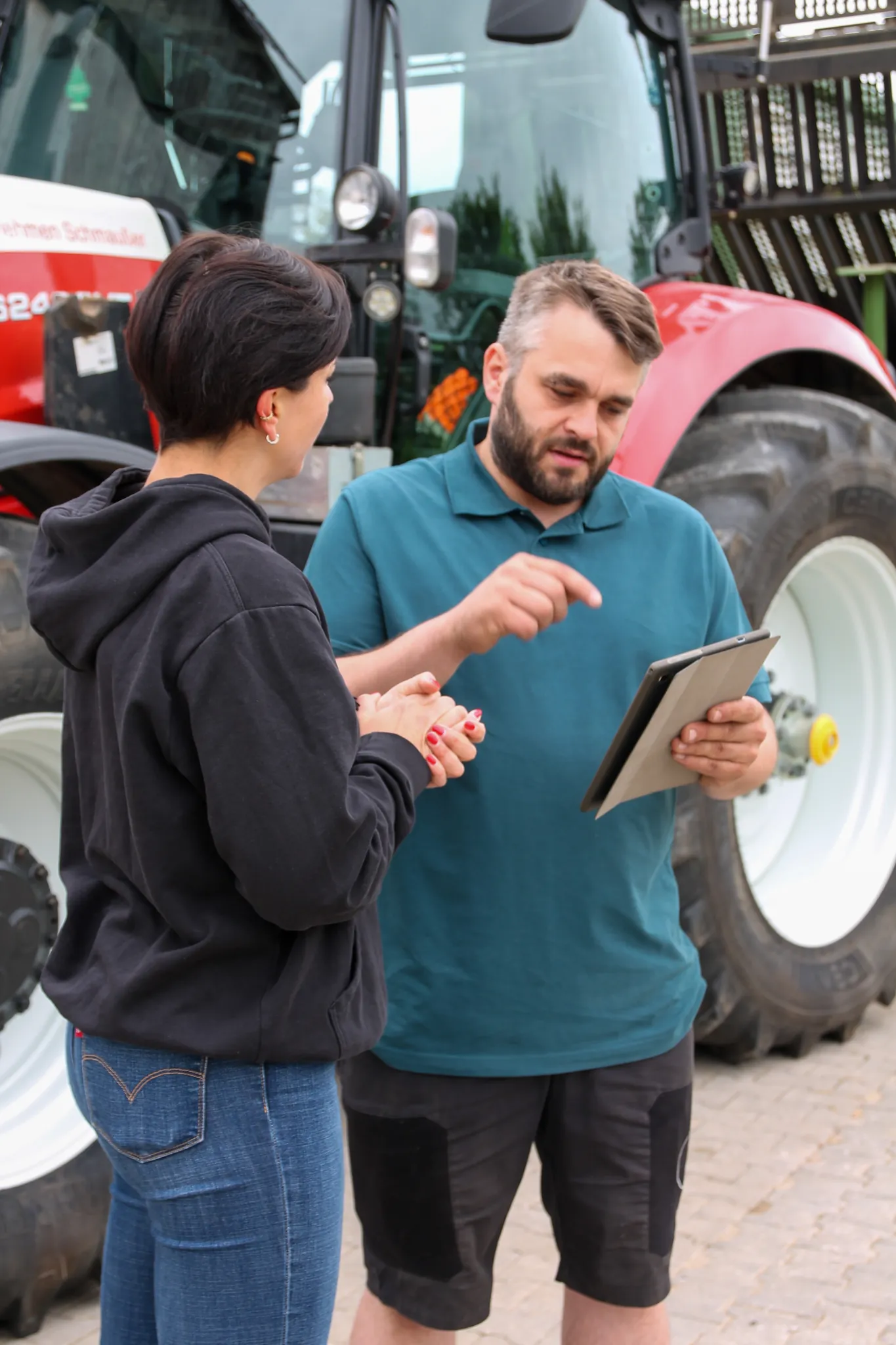 Sebastian Schmaußer im Gespräch mit einem FarmAct Mitarbeiter am Traktor