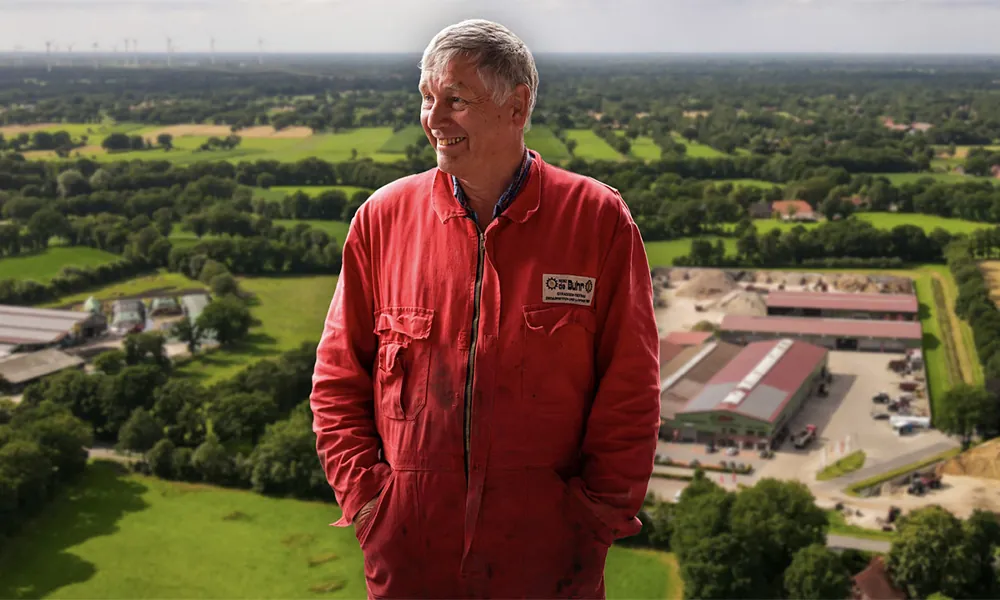 Heinz de Buhr vor der Luftaufnahme seines Betriebs in Ostfriesland