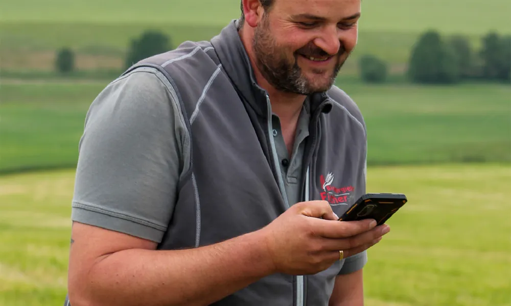 Landwirt prüft Auftragsdaten auf dem Smartphone