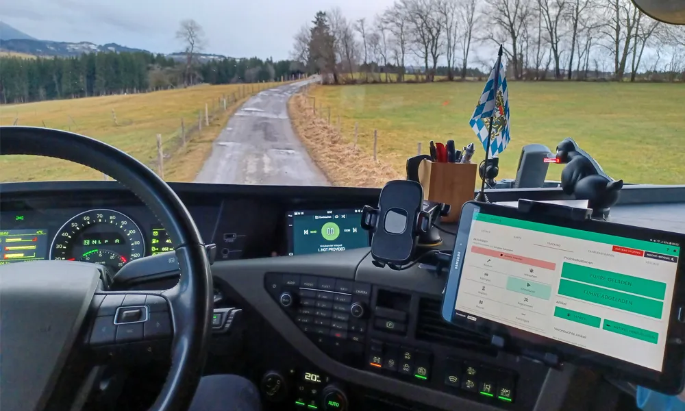 Blick aus der Lkw-Kabine auf die FarmAct App am Tablet