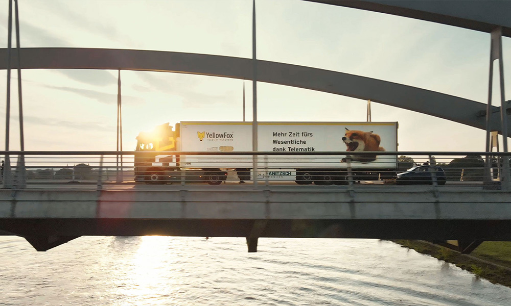 LKW von YellowFox fahrend auf einer Brücke