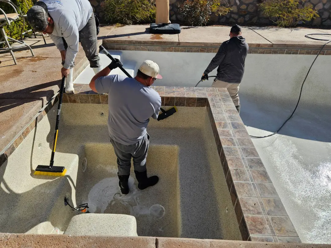 a group of men cleaning a pool
