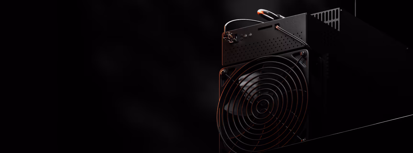 Close-up of a black electronic device with a large cooling fan and cables against a dark background.