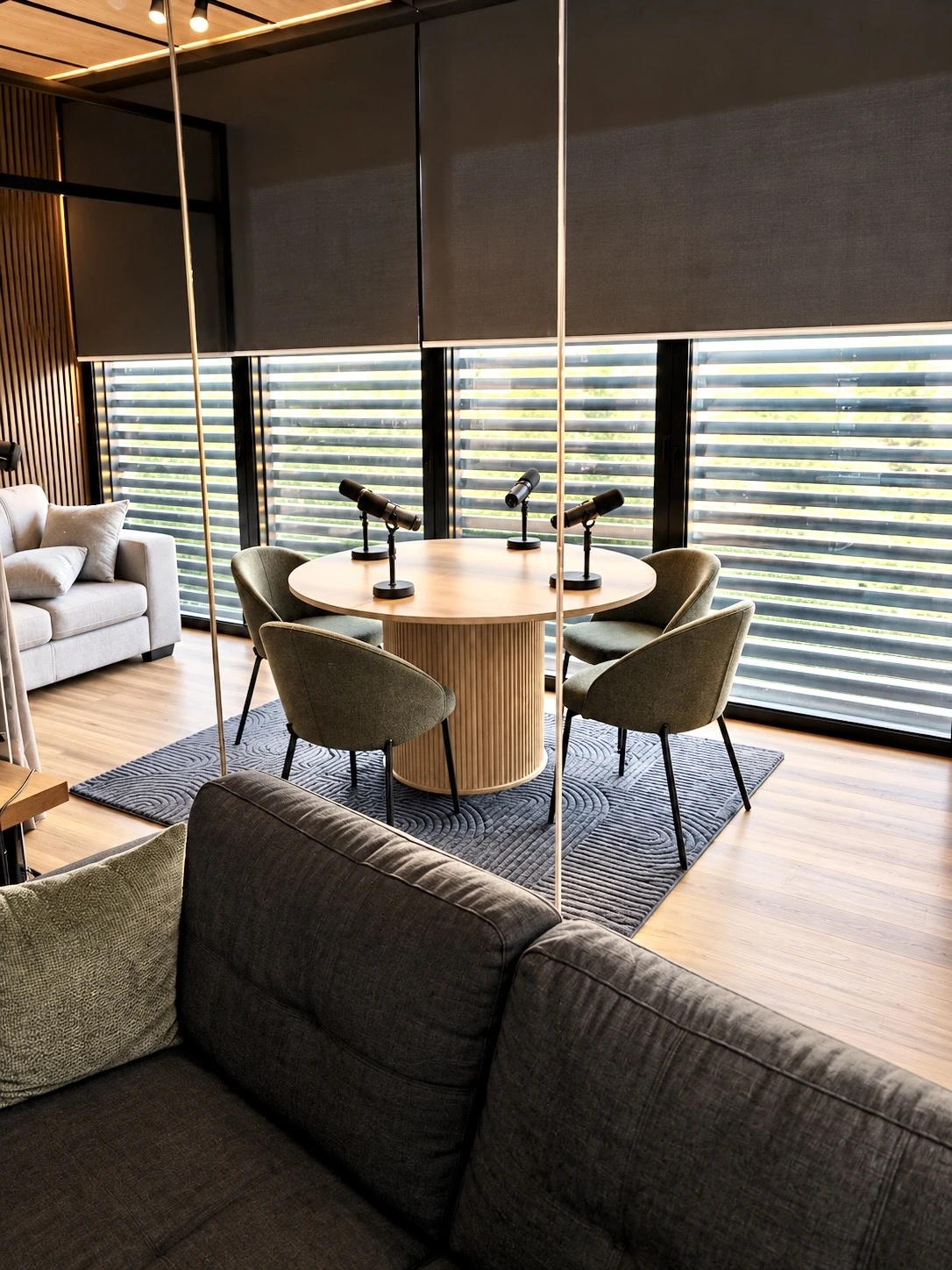 Podcast table and lounge beside the studio windows