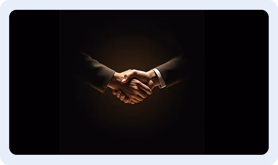 Two people in suits shaking hands against a dark background, symbolizing agreement or partnership.