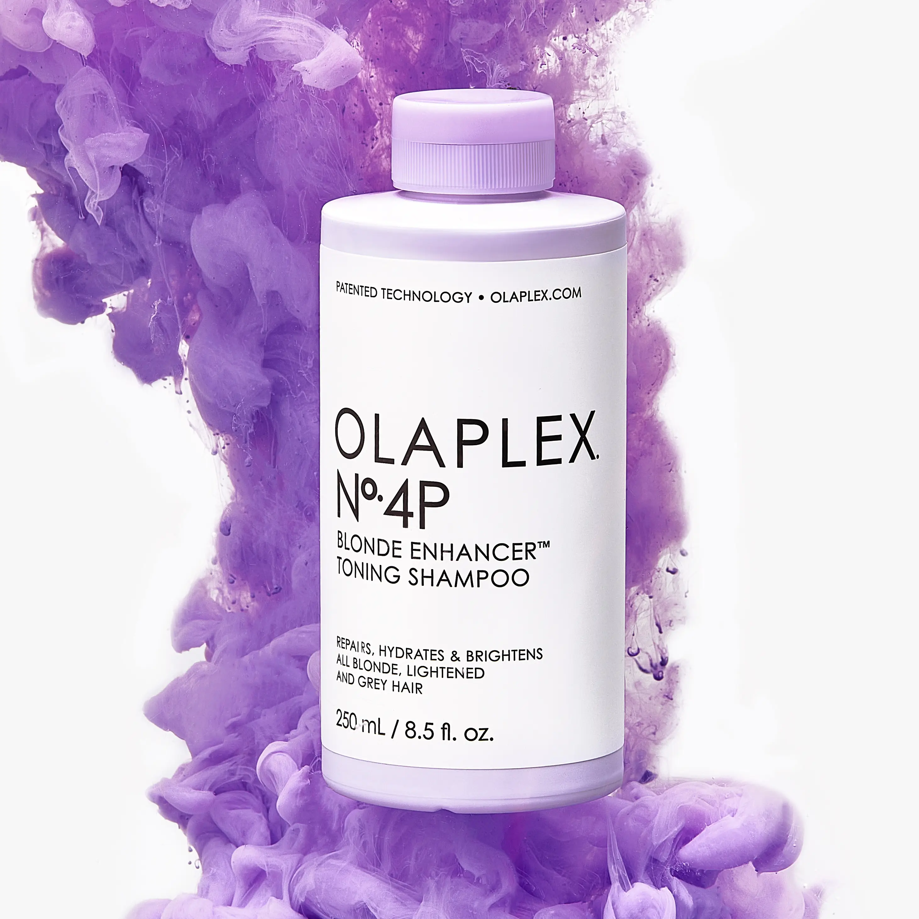 Bottle of Olaplex No.4P Blonde Enhancer Toning Shampoo surrounded by purple smoke.