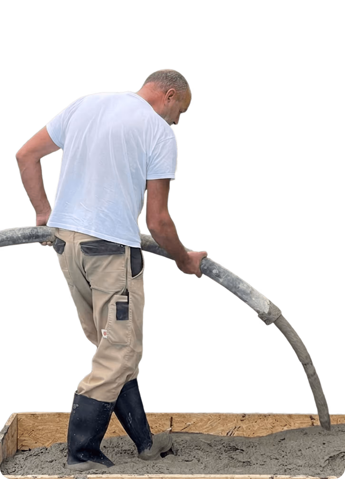 Mann in Arbeitskleidung pumpt Beton in eine Bauform, trägt Gummistiefel, mit schwarzem Hintergrund.
