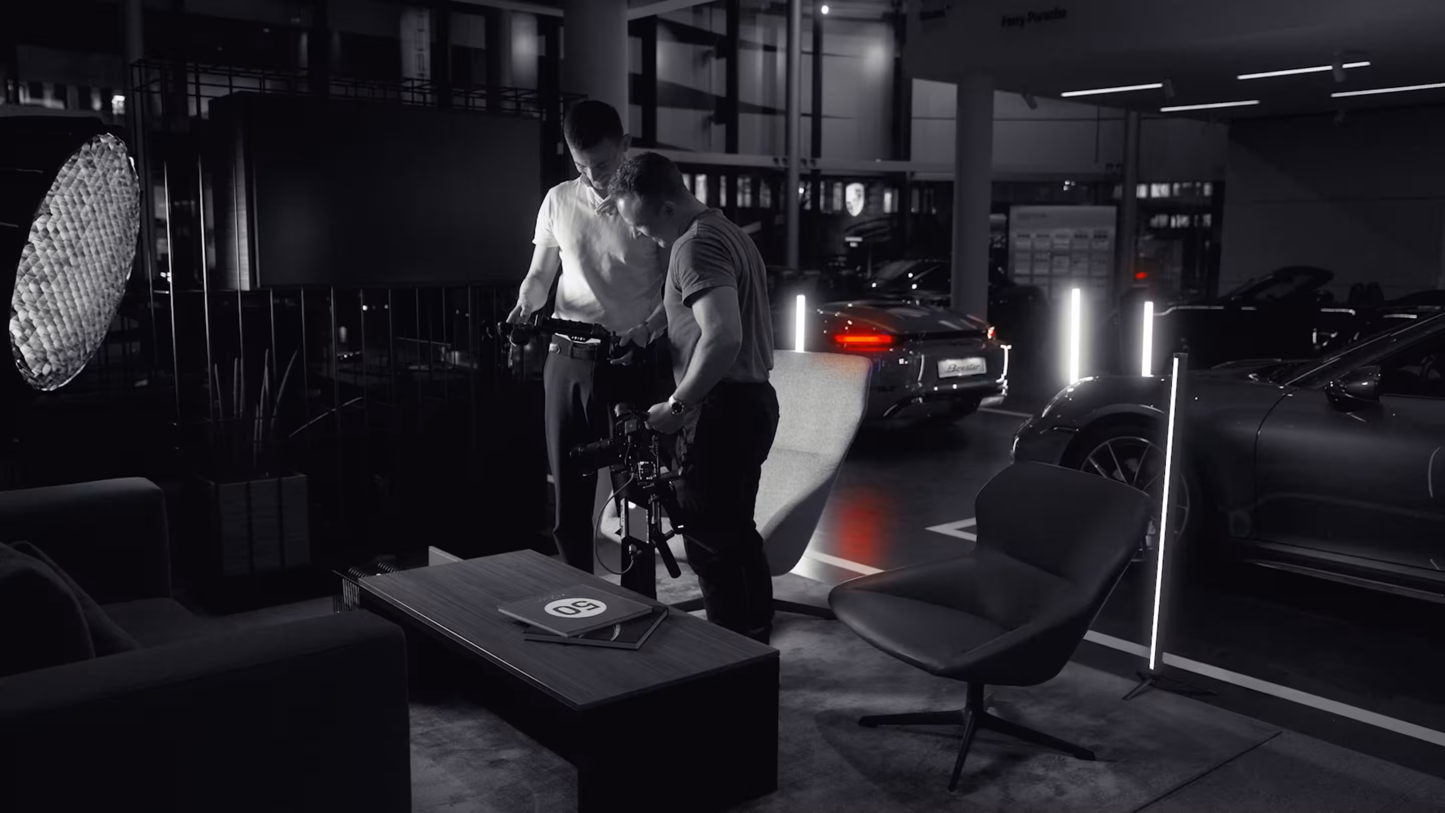 Zwei Personen die Videomaterial ansehen, in einem Porsche Autohaus