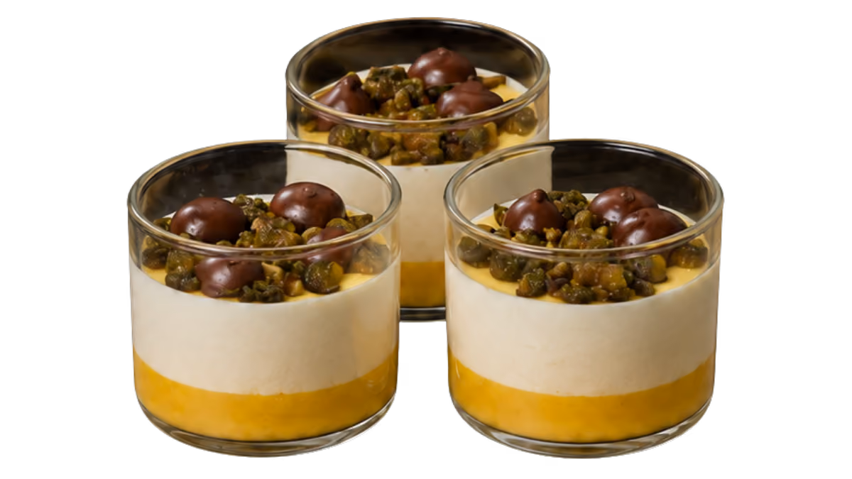 Creme aus fruchtigen Orangen mit karamellisierten Salz-Pistazien und Schokoladentropfen im Porzellantässchen