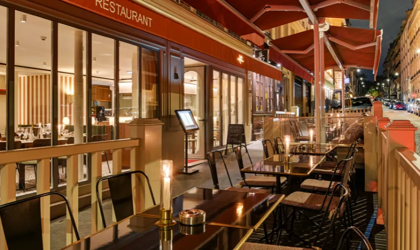 Candlelit restaurant terrace with a red awning, evening atmosphere