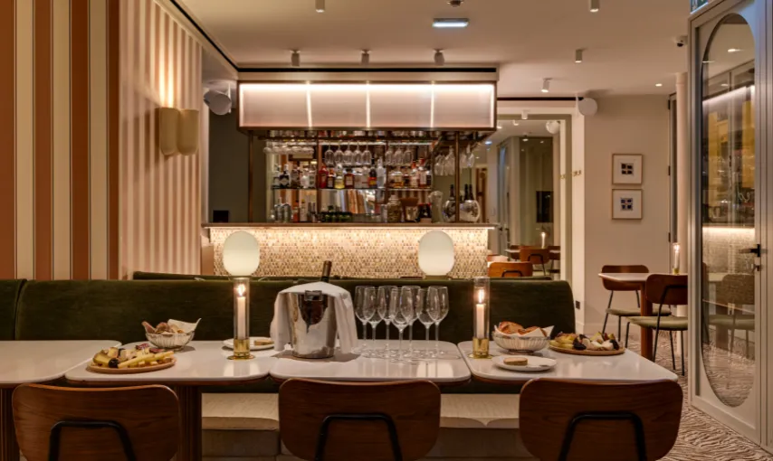 Bar and dining area with wooden stools, candles and illuminated bottle racks