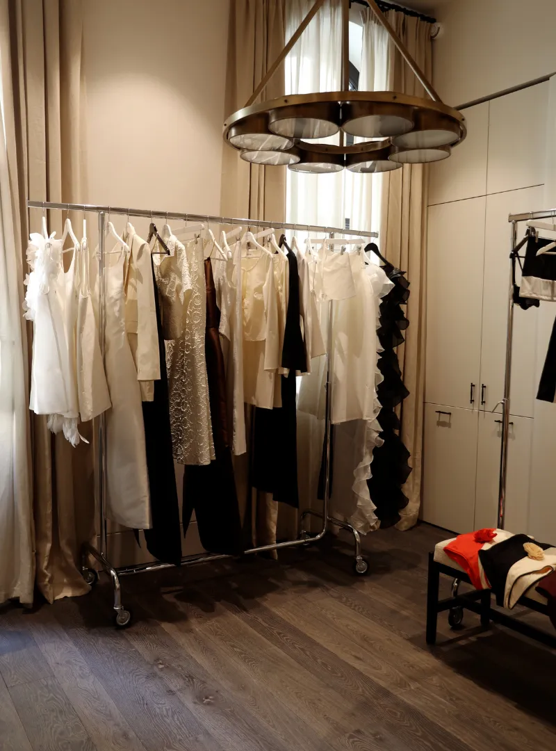 Walk-in wardrobe with clothes rails and a designer pendant light