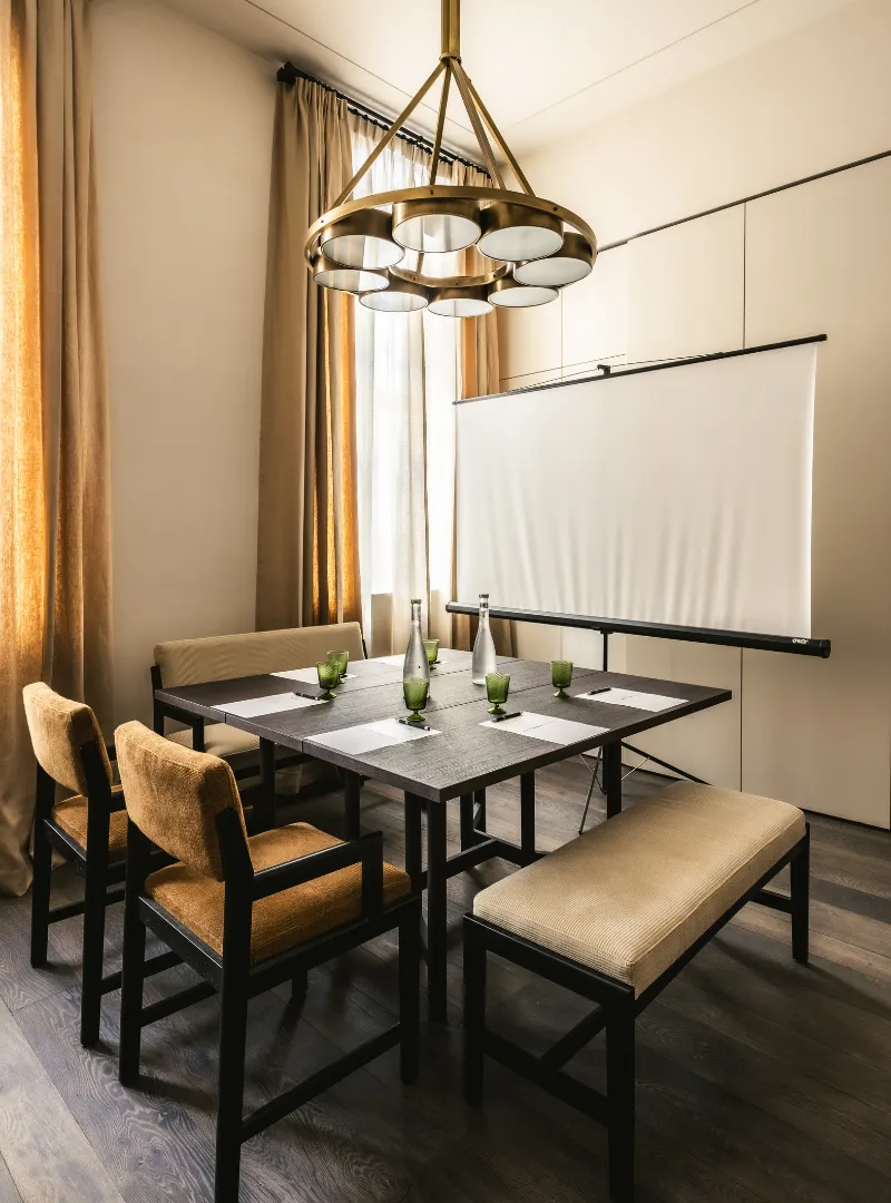 Dining room with a wooden table, leather chairs, a bench and a designer pendant light