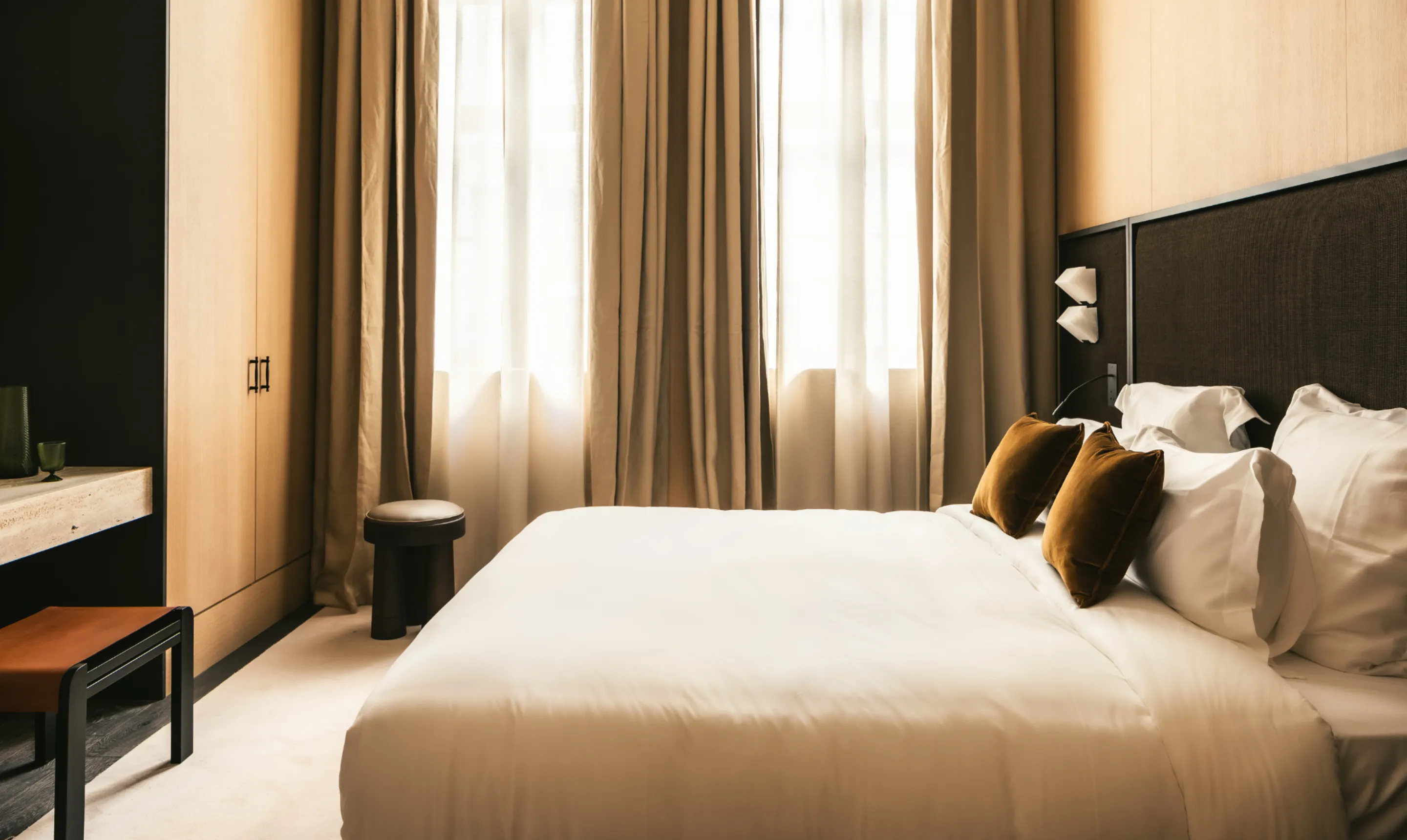 Chambre d'hôtel avec lit double, tête de lit capitonnée et éclairage tamisé