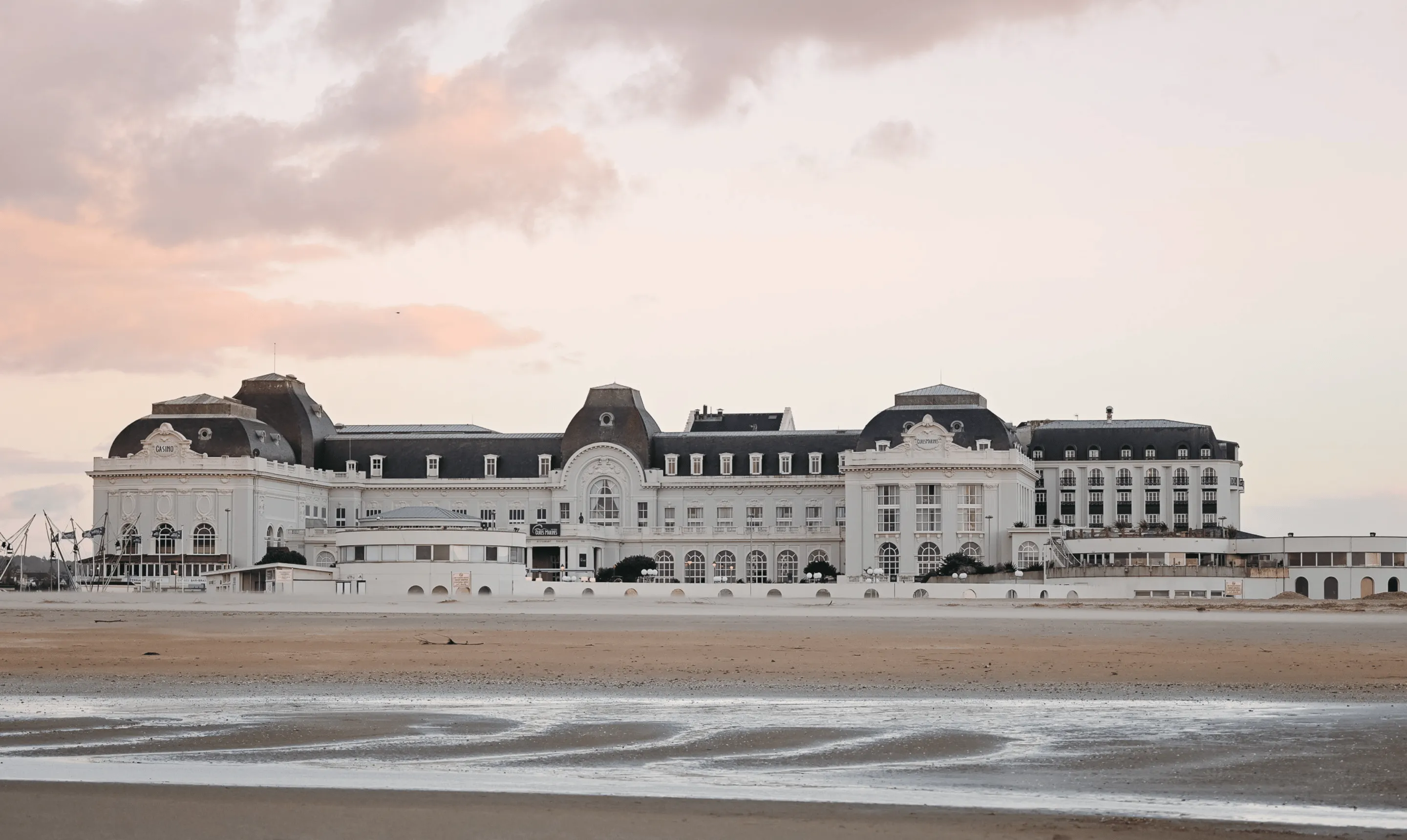 Vue extérieure d'un bâtiment en bord de mer avec façade claire et grandes fenêtres