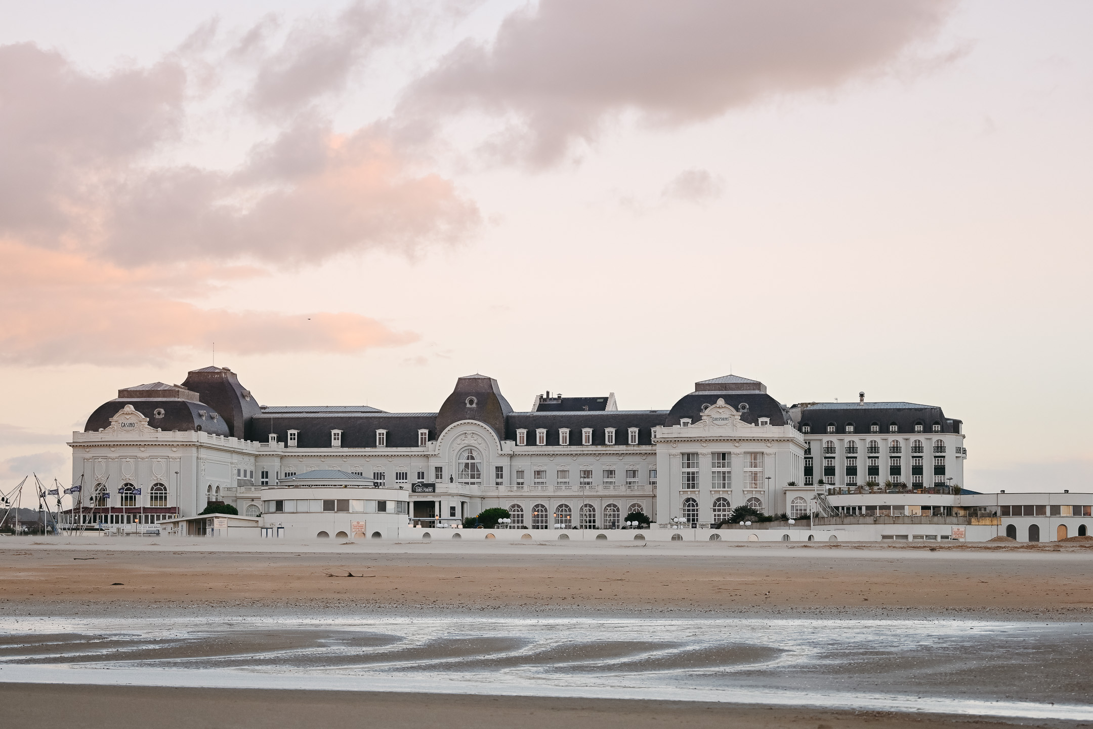 Vue depuis la plage sur la façade majestueuse de l'hôtel Cures Marines au coucher du soleil