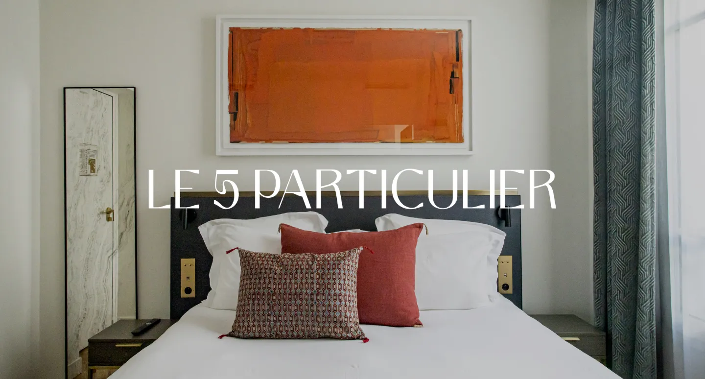 le5particulierChambre Le 5 Particulier avec lit noir et coussins bordeaux, tableau abstrait orange au mur