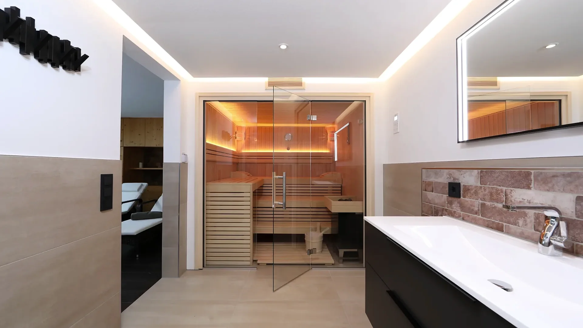 Beleuchtete Holzsauna mit Ganzglasfront in modernem Badezimmer, klassische Sauna nach Mass von RR Variationen