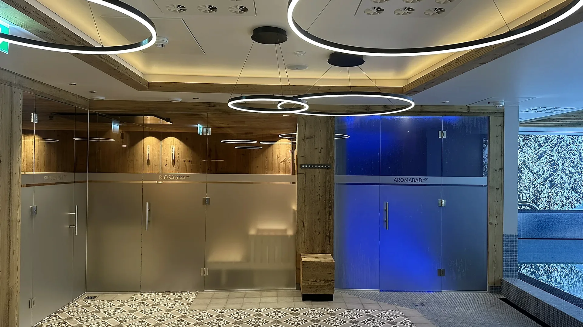 Hotel-Wellnessbereich mit zwei Saunen hinter Milchglastüren und Ringleuchten, klassische Sauna von RR Variationen