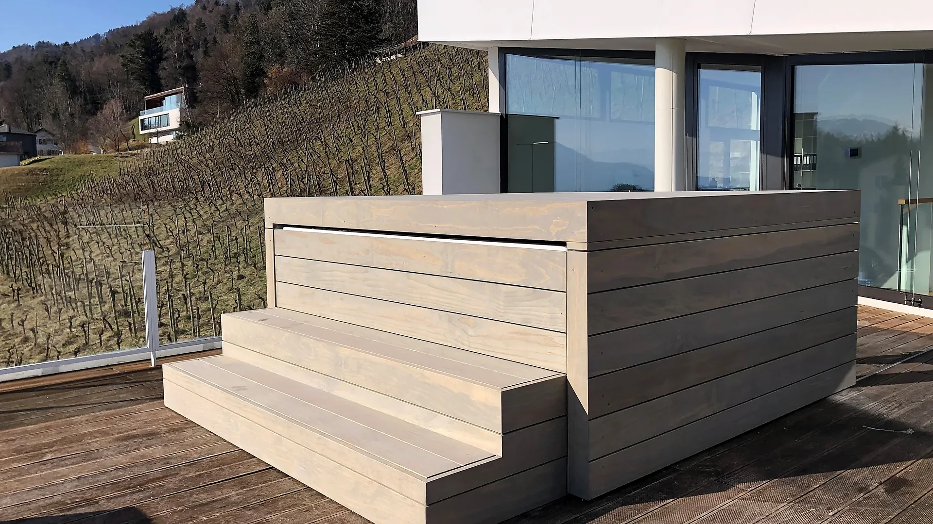 Geschlossene Holzabdeckung auf verkleidetem Whirlpool mit Treppe auf einer Terrasse am Rebberg, Abdeckung von RR Variationen