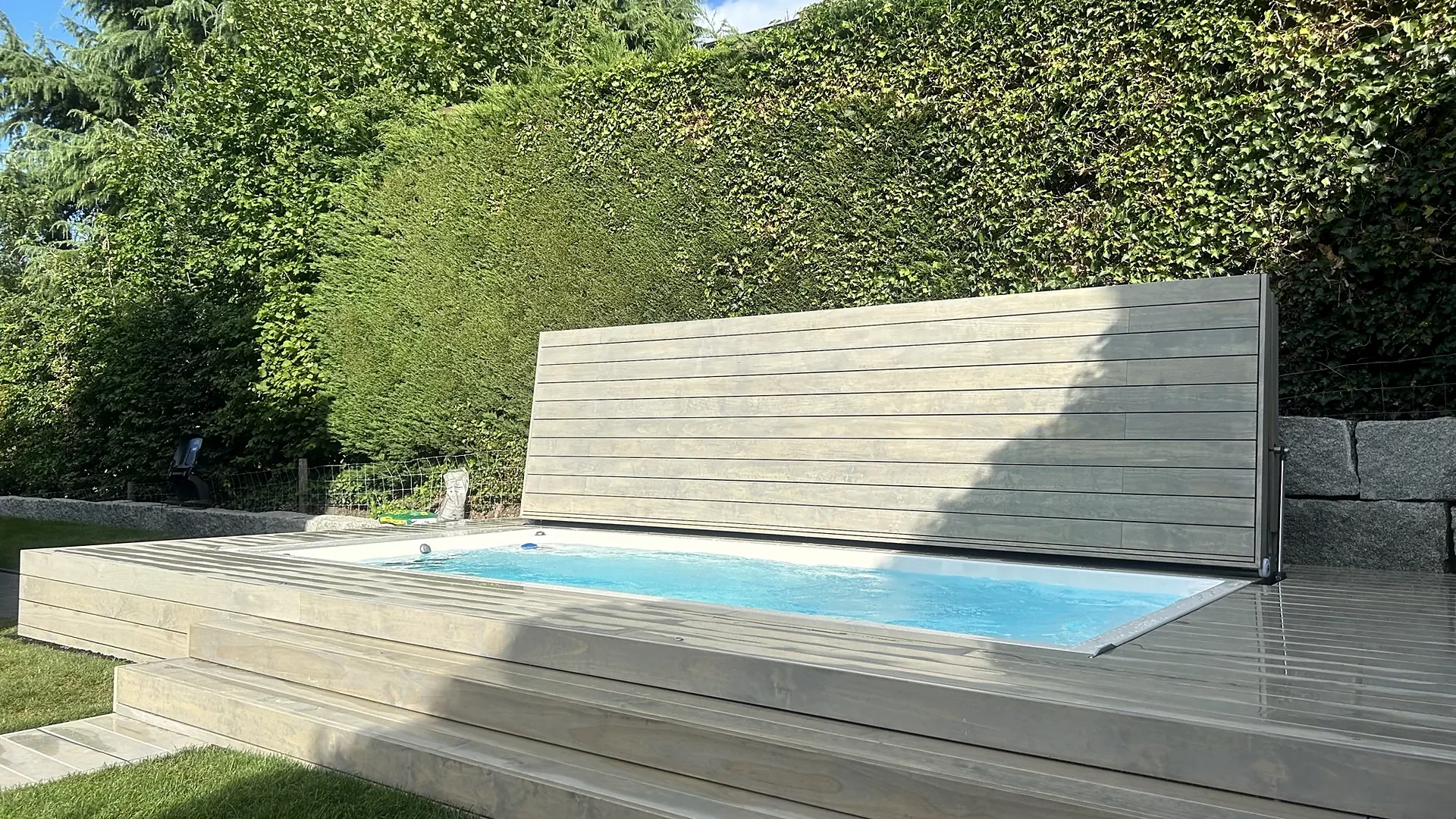 Aufgestellte Holzabdeckung als Sichtschutz hinter eingelassenem Swim Spa im Garten, Abdeckung nach Mass von RR Variationen