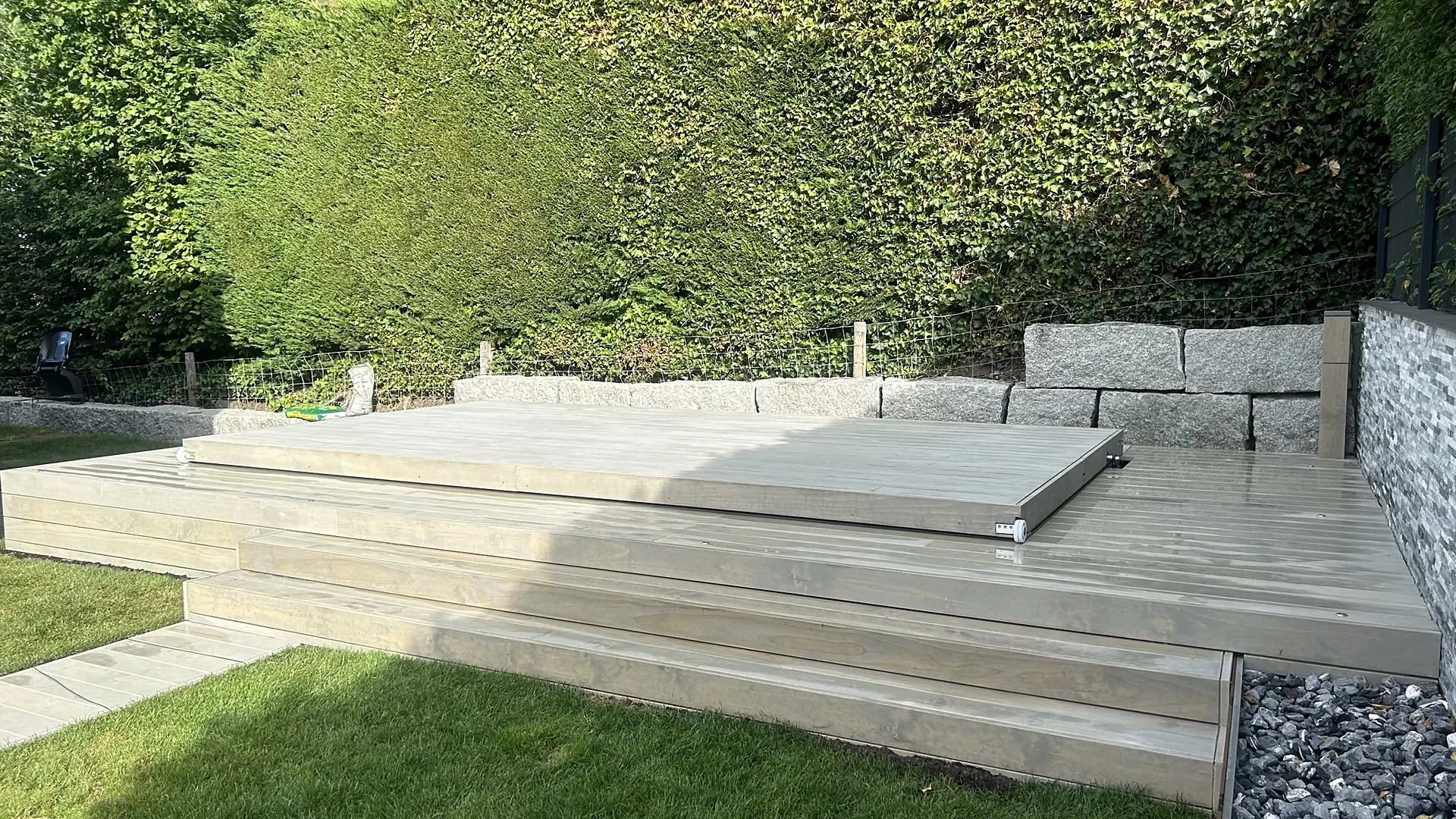 Geschlossene begehbare Holzabdeckung auf einem Swim Spa im Holzdeck vor Hecke, Abdeckung nach Mass von RR Variationen