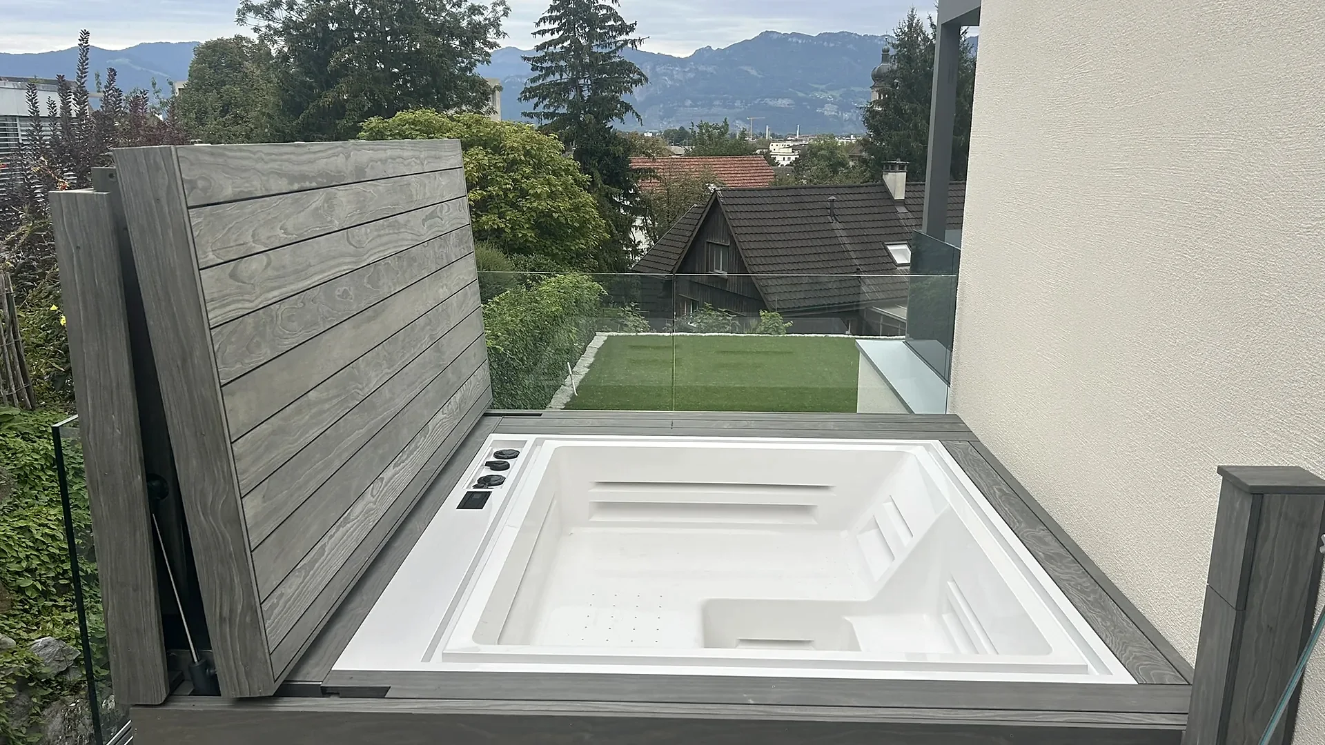 Eingebauter Whirlpool mit aufgeklapptem Holzdeckel auf Balkon mit Bergsicht, Whirlpool nach Mass von RR Variationen