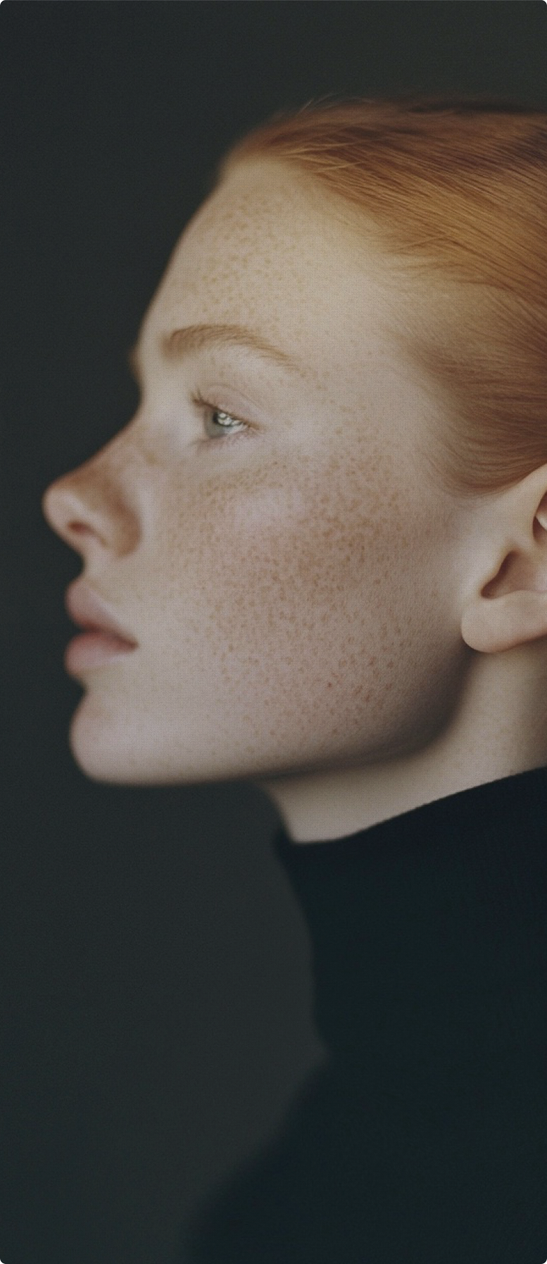 Woman in profile against a dark background, showing natural facial contour