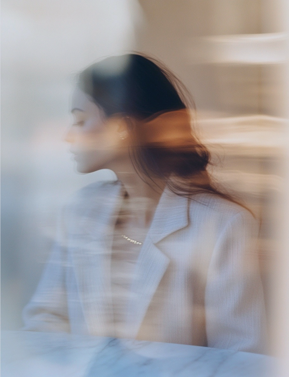 Woman in motion wearing a light-colored coat