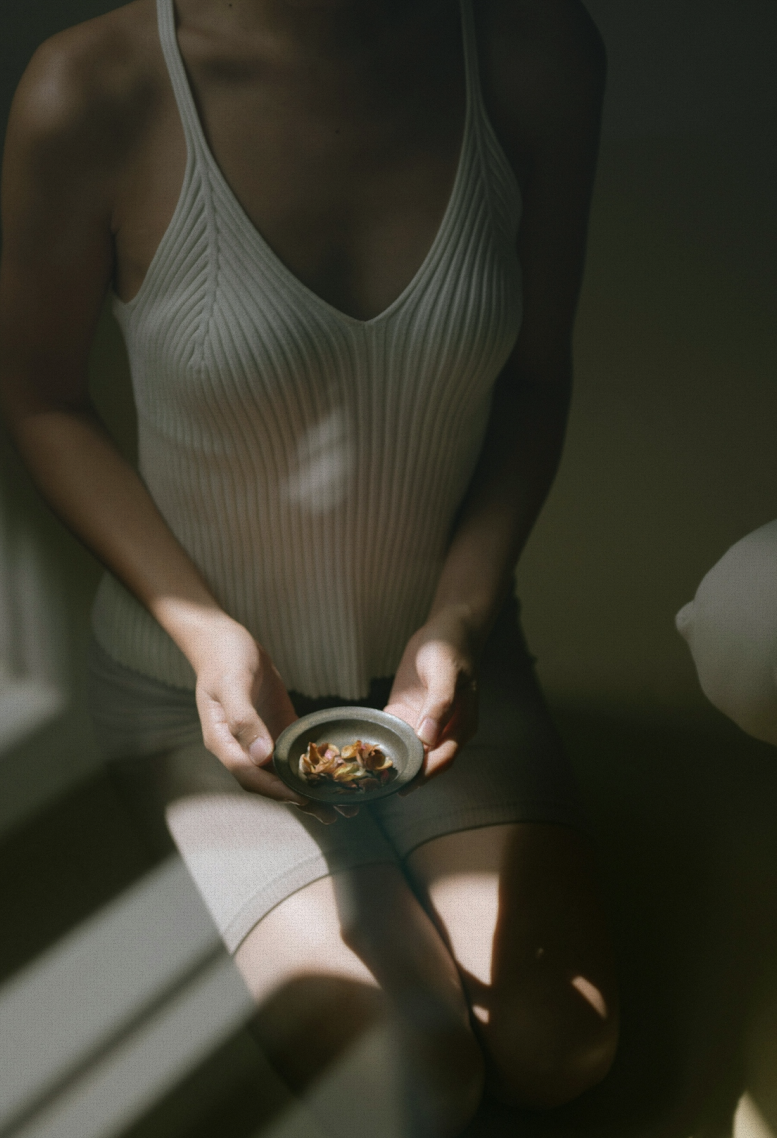 Woman holding a bowl, hands visible in soft light