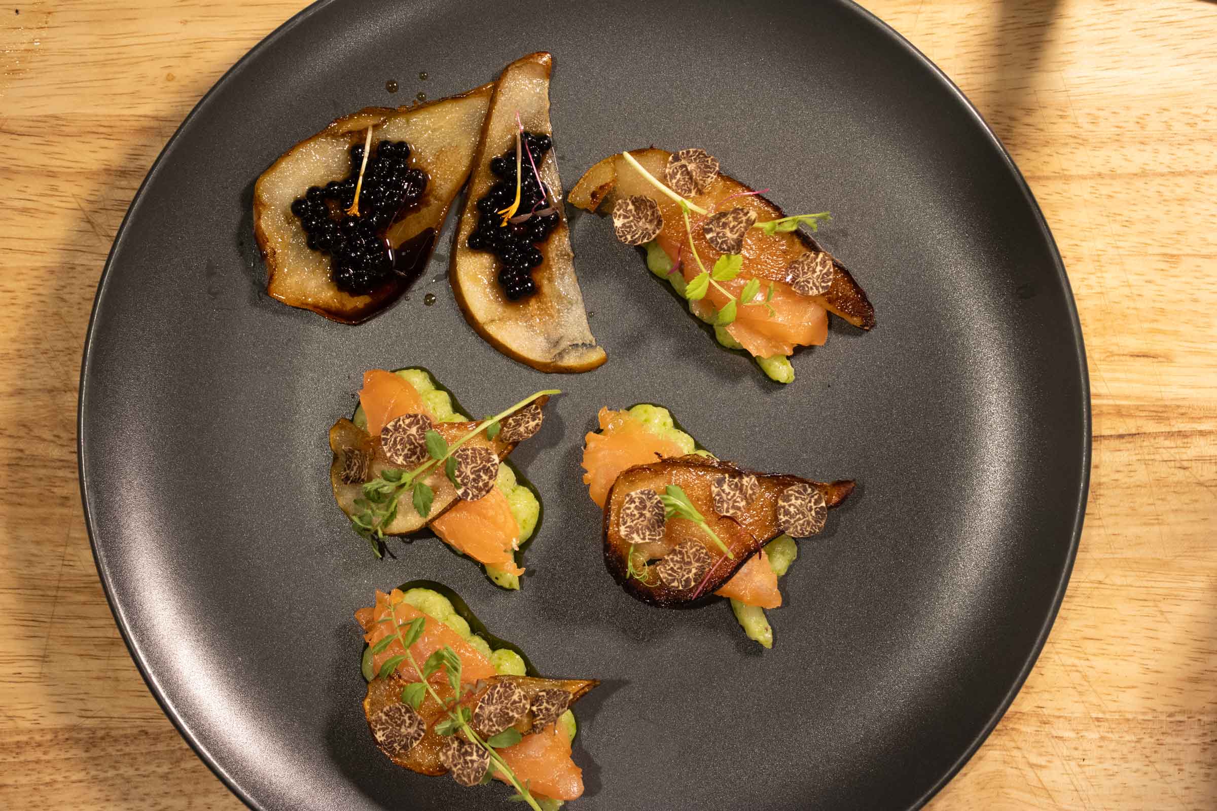Truffle-topped canapés on a dark plate